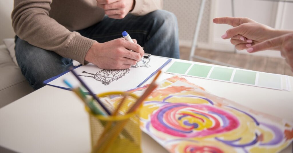 homme qui dessine avec une art-thérapeute