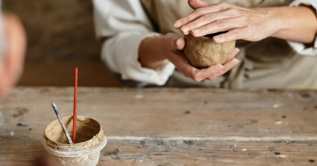 femme qui façonne l'argile dans un cours de poterie