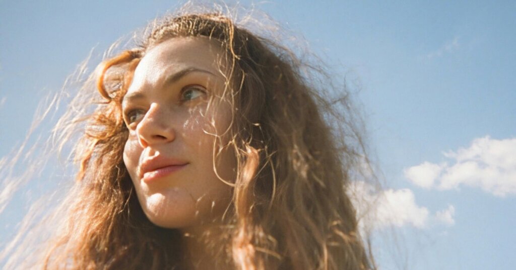femme qui porte un sourire serein en pleine nature