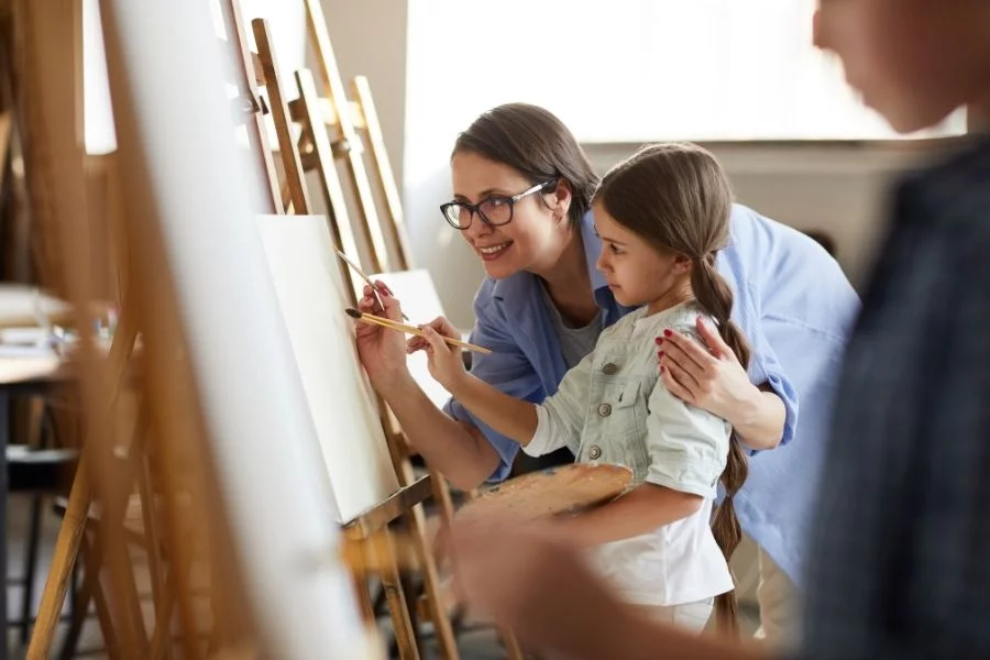 art-thérapie enfant qui peint avec une professeure